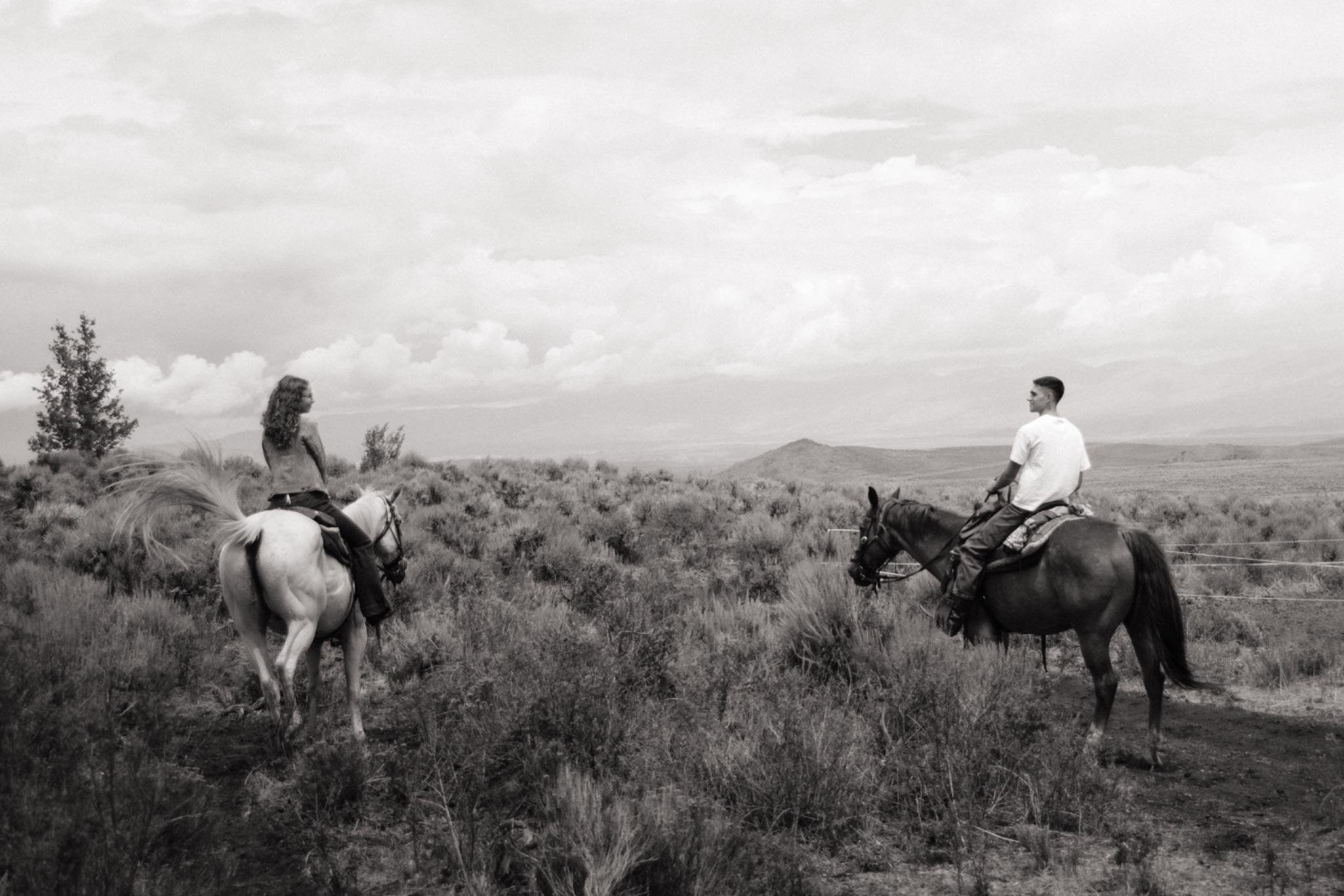 Jonathan and Amaryllis riding horses together at golden hour